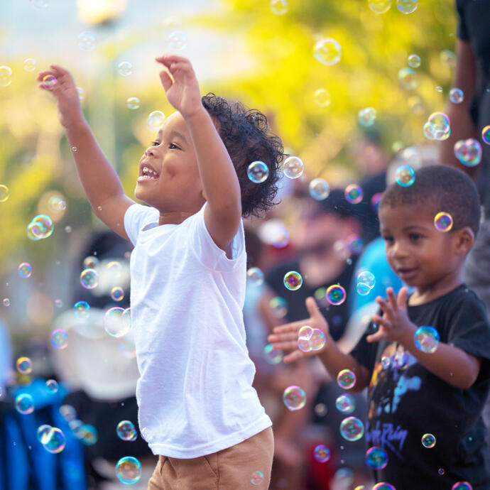 Two young boys trying to catch bubbles