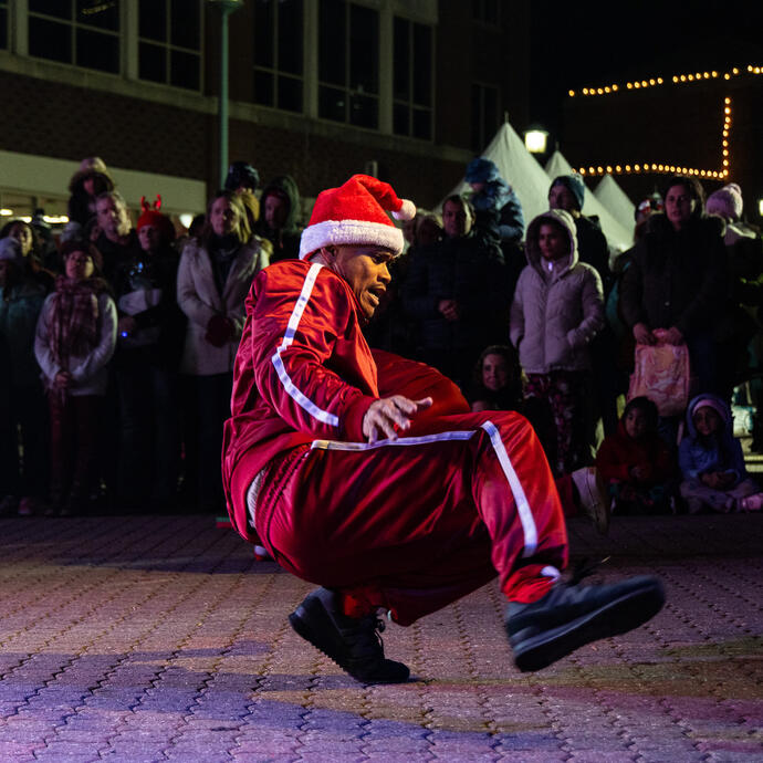 A breakdancer dressed as Santa Claus