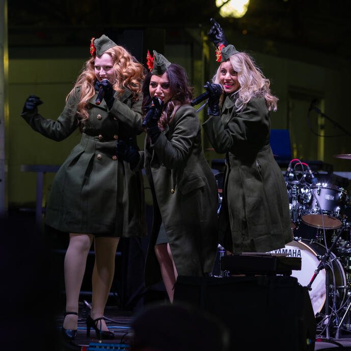 Three women singing on a stage