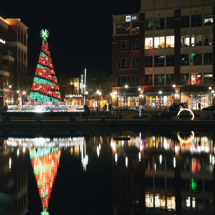 The holiday tree at Lights at the Fountain reflecting in the fountain